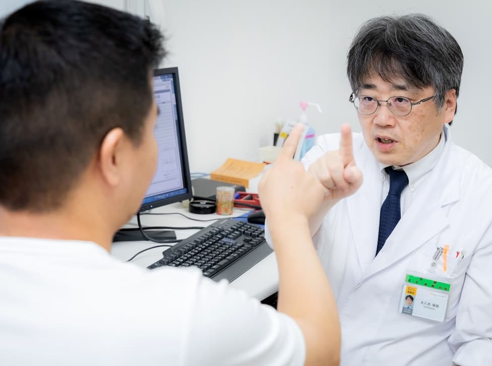 写真：大八木教授が指と指を合わせる診療している様子
