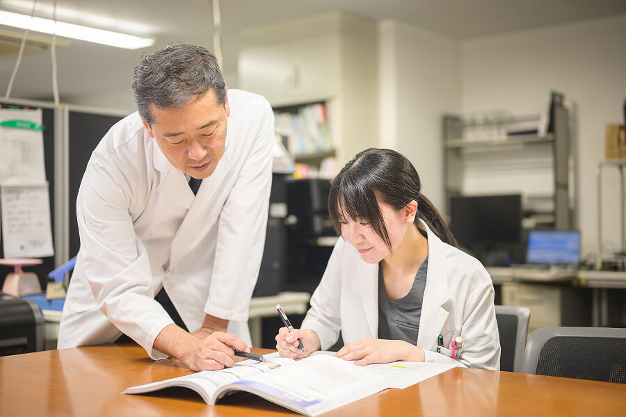 写真:文献を見ながら指導している様子