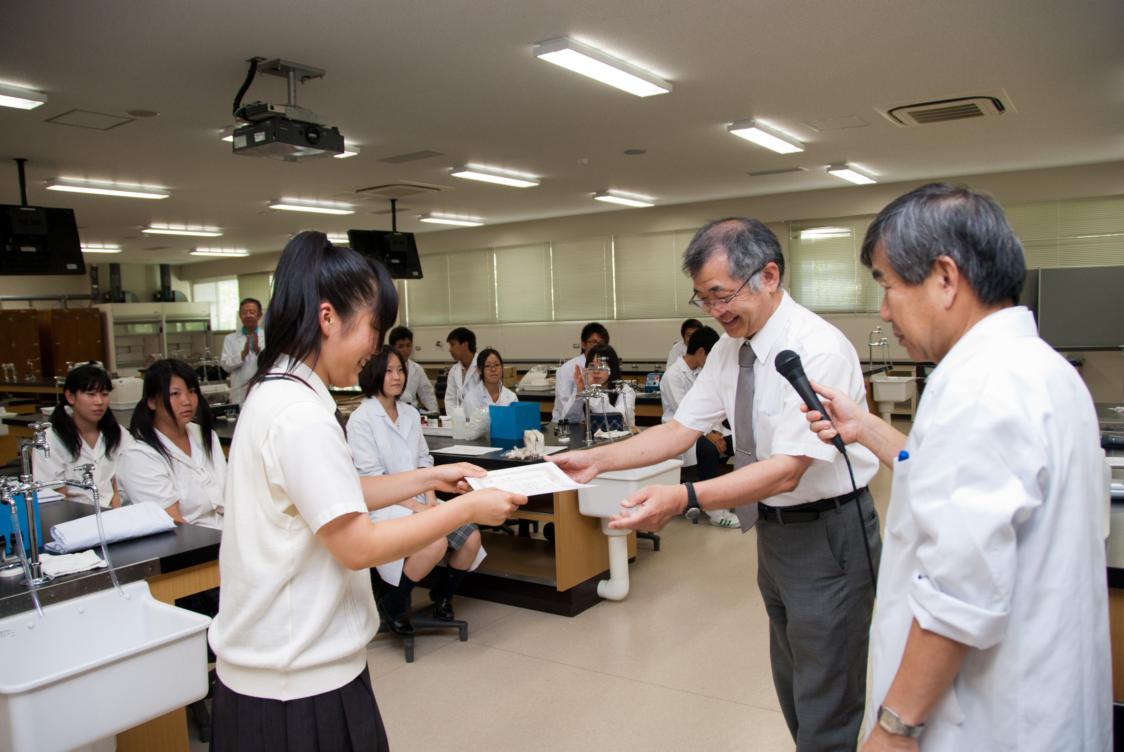 無事実験を終え修了証を受け取る高校生