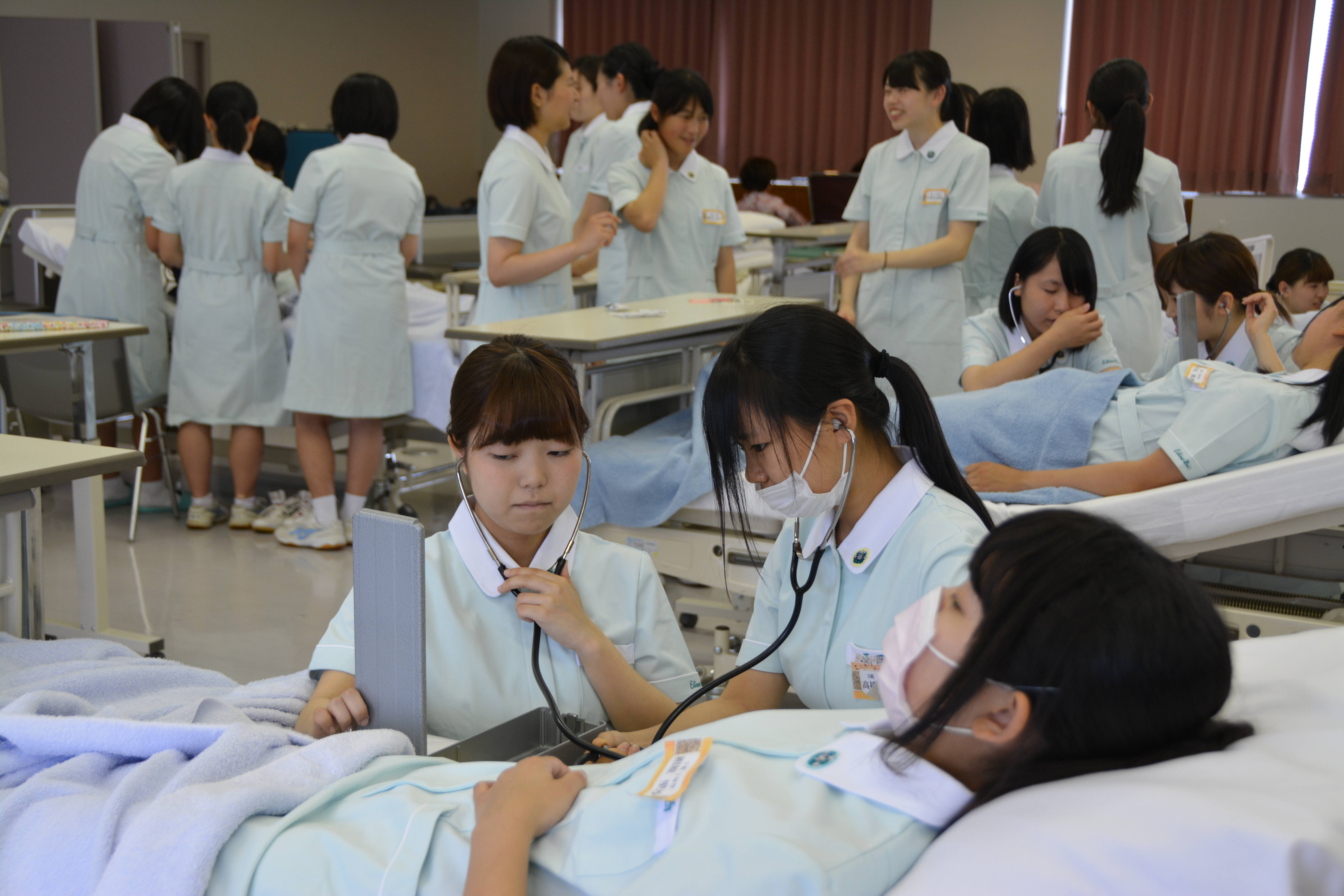 看護体験で脈をひろう高校生